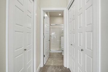 Hallway with two white doors leading to a bathroom