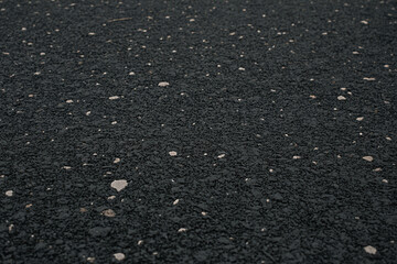 Black rubber flooring surface texture background with white specks for gym playground safety surface