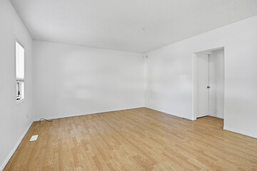 Large empty room with a wooden floor and white walls