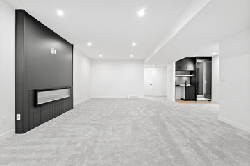 Large, empty living room with a fireplace and a kitchen