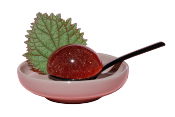 Close-up of sparkling molecular gastronomy sphere with a fresh herb on a minimalist plate. Elegant, experimental food design on transparent background