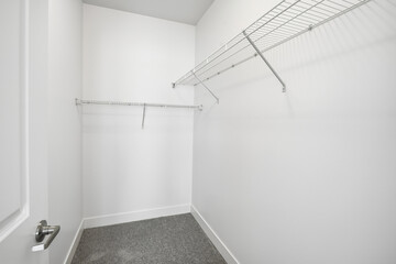 Small, empty closet with a metal rack on the wall