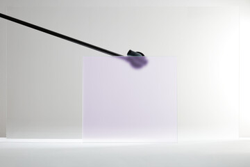 Abstract Minimalist Composition of a Frosted Lavender Glass Panel and Diagonal Black Rod in a Bright Studio Environment.