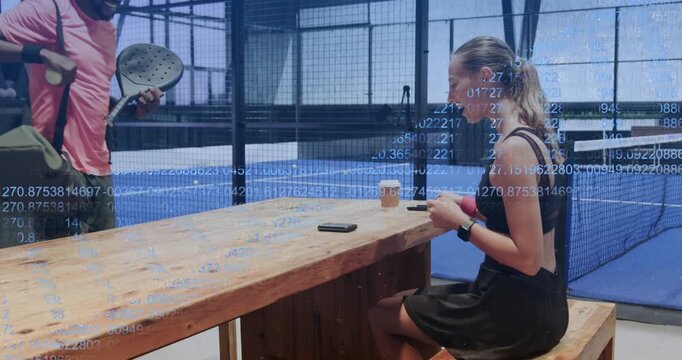 woman tapping smartphone at table padel coach coming with rackets, ball fist bumping practicing