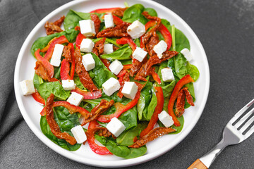 Spinach salad with sun dried tomato feta and red pepper concept for wellness food or vegetarian lunch menu photography