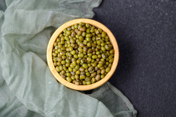 Green Mung Beans In Wooden Bowl On Fabric And Black Background