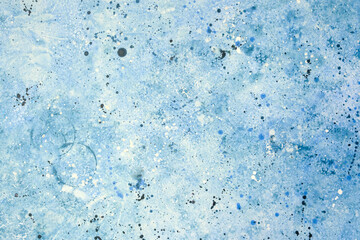 Abstract blue artwork featuring textured patterns and splashes of color