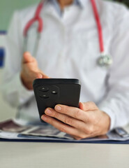 Doctor checking phone while discussing patient health in a clinical