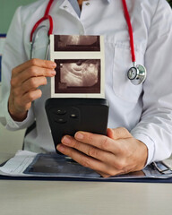 Doctor reviewing ultrasound images while consulting with a patient in a medical office