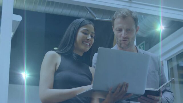 Woman navigating laptop trackpad while man writing in notebook in office boosting joint review