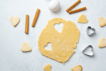 Heart shaped cookie dough cutting with cinnamon and eggs for baking, valentines or romantic concept