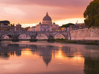 Stunning sunset view of St. Peter&rsquo;s Basilica and Ponte Sant&rsquo;Angelo reflecting in the Tiber River in Rome, Italy.
