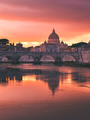 Stunning sunset view of St. Peter&rsquo;s Basilica and Ponte Sant&rsquo;Angelo reflecting in the Tiber River in Rome, Italy.