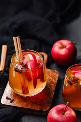 Spiced apple cider with cinnamon sticks and star anise in glasses. Served on wood board. © reddish