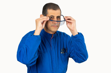Mechanic worker putting protective glasses before work with white background.