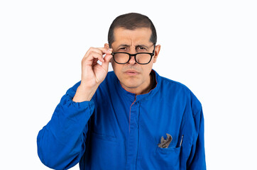 Mid adult with mechanic uniform and glasses straining his eyes because he can't see, isolated with white background