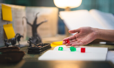 Man hand dice roll d4 for critical hit attack role playing tabletop game and board game hobby