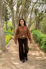 Young woman walking forest path, enjoying nature relaxation