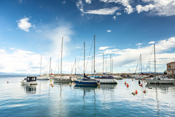 Boats and sailboats moored in the harbor of Opatija, Croatia on a sunny day with calm sea and blue sky