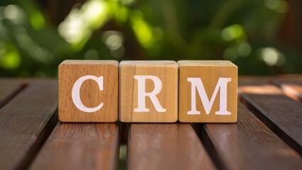 Wooden blocks spelling CRM for customer relationship management displayed on wooden table with blurred background