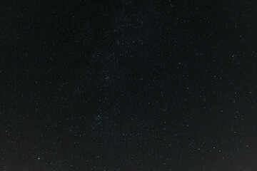 A breathtaking view of the star-filled night sky, showcasing countless stars and a faint band of the Milky Way stretching across the darkness.