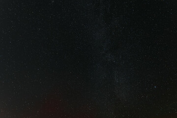 A breathtaking view of the star-filled night sky, showcasing countless stars and a faint band of the Milky Way stretching across the darkness.