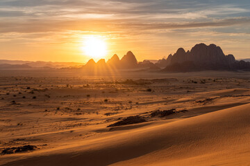 Desert landscape, sand dunes and rocky mountains sunset. Dramatic view sahara. Red Mars like landscape. beautiful rock formations. Orange red sand desert, rocky formations and mountains background.