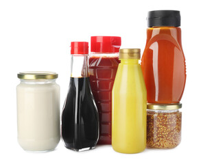 Bottles and jars with different tasty sauces isolated on white