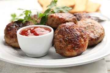 Delicious patties with parsley and ketchup on table, closeup