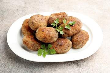 Tasty meat patties with parsley on grey table, closeup