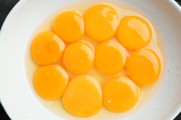 Egg yolks in bowl on table, top view