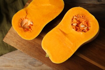 Halves of fresh pumpkin on wooden table, top view