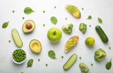 Fresh avocado toasts, green vegetables fruit white concrete background top view, diet, vegetarian food. Assorted green healthy products, clean eating nutrition