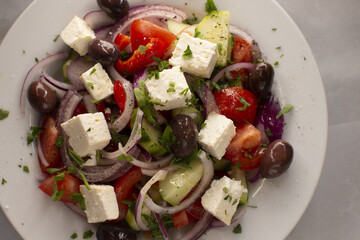 A delicious Greek salad featuring vibrant, fresh tomatoes, cucumbers, onions, olives, and creamy feta cheese