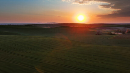Sunset wavy hills with agricultural fields