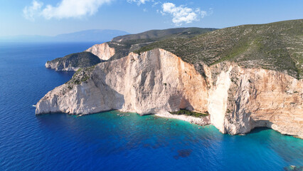 Aerial drone photo of famous steep rocky white cliffs creating beautiful coves and turquiose sea caves of Kampi visited by small boats and yachts in northern part of Zakinthos island, Ionian, Greece