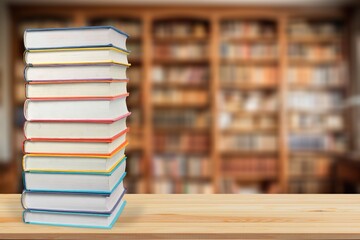 stack of reading books on desk in library