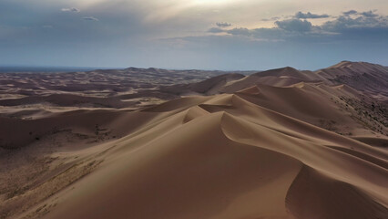 Aerial view of sand dunes in desert at sunset