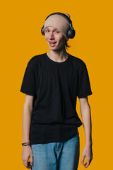 A Young Person Enjoying Music with Headphones Against a Bright Orange Background