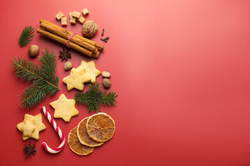 Christmas composition with cookies in shape of stars, spices and fir tree branches on red background, flat lay. Space for text