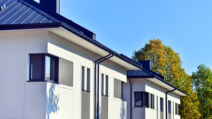 Harmony with nature, eco architecture. Terraced single family homes in newly developed housing estate. The real estate market in the suburbs with lush greenery surrounding. 