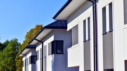 Harmony with nature, eco architecture. Terraced single family homes in newly developed housing estate. The real estate market in the suburbs with lush greenery surrounding. 