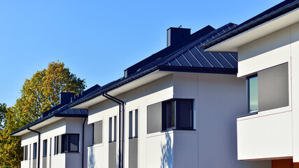 Harmony with nature, eco architecture. Terraced single family homes in newly developed housing estate. The real estate market in the suburbs with lush greenery surrounding. 