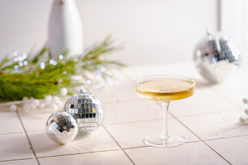 Christmas and New Year celebration with champagne. New Year holiday decorated table. Festive New Year champagne and silver baubles. Close up. Christmas greeting card with copy space.