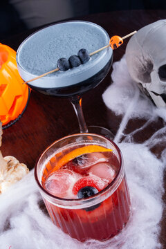 themed and decorated halloween drinks seen from above with morticia adams and negroni with eye ice