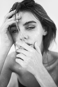 beautiful woman with natural makeup, wet hair, and sparkling glitter on her skin. 