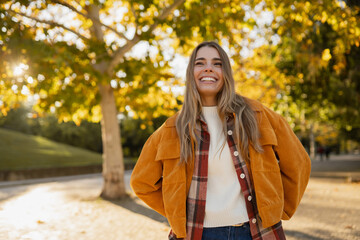 young beautiful blond woman walking in autumn park, stylish , smiling, happy, trendy season warm outfit, wearing velvet terracotta color jacket