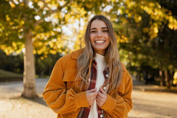 young beautiful blond woman walking in autumn park, stylish , smiling, happy, trendy season warm outfit, wearing velvet terracotta color jacket