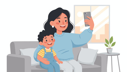 A joyful Asian mother and her young son are happily taking a selfie together while sitting on a comfortable sofa in their living room, capturing a precious family moment with a smartphone