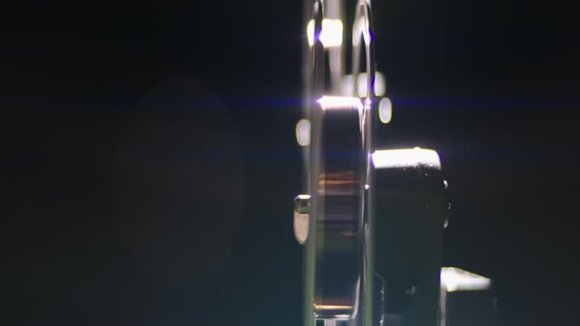 Old-fashioned film projector operating in a dark room with reels spinning as the celluloid tape runs through the mechanism, evoking nostalgia for classic cinema and analog entertainment